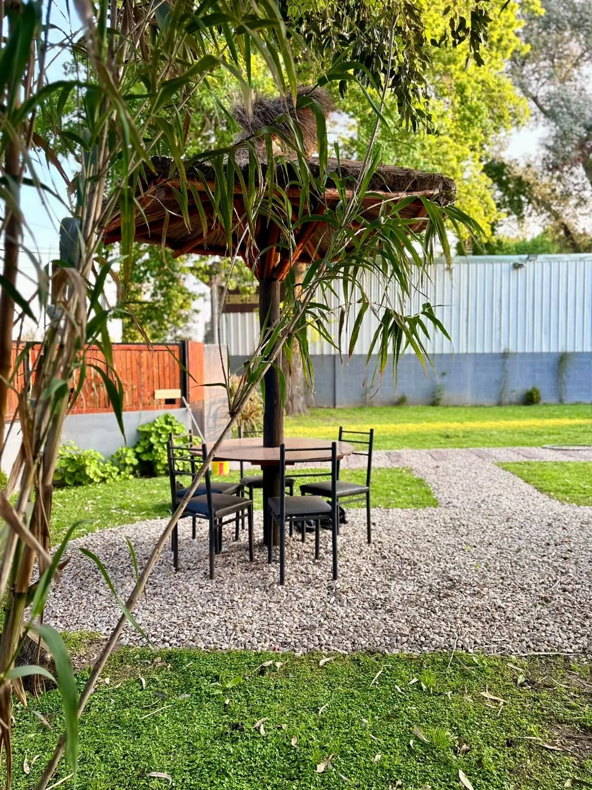 Mesa bajo sombrilla de paja entre plantas